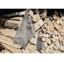 Treillis métallique devant une pile de bois