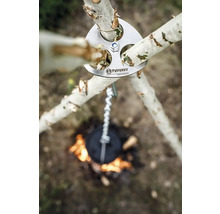 Logo Petromax au-dessus d''un trépied avec chaîne au-dessus d''un feu de camp.