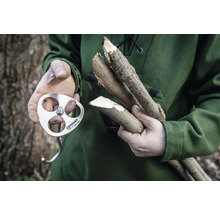 Une personne tient un crochet d''allumage Petromax et des morceaux de bois.