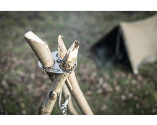 Logo Petromax, adaptateur trépied avec morceaux de bois et tente en arrière-plan