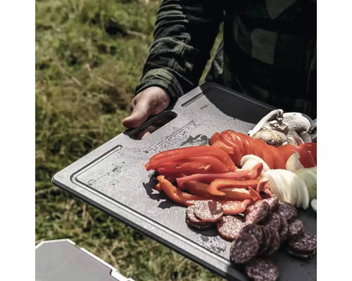 Personne tenant une planche à découper avec des saucisses, des poivrons, des oignons et des champignons