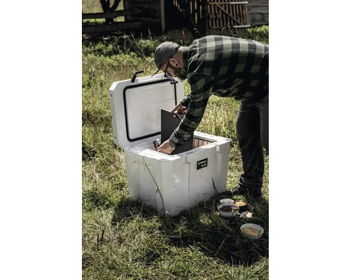 Un homme remplit une glacière Perovskite à l''extérieur.