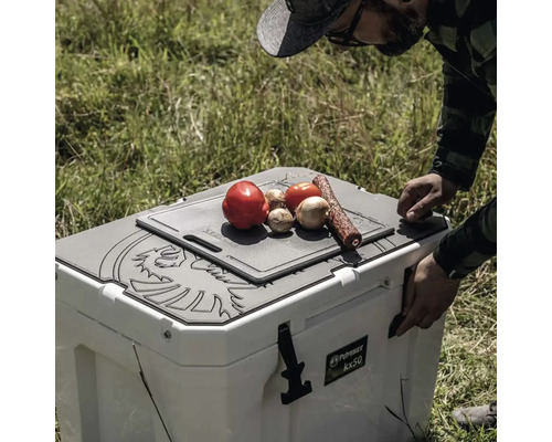 Glacière Petromax avec planche à découper et aliments dans une scène extérieure