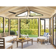 Pavillon lumineux avec meubles en bois, ventilateur de plafond et vue sur le jardin