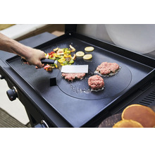 Des légumes et des hamburgers sont préparés sur une plaque de cuisson.