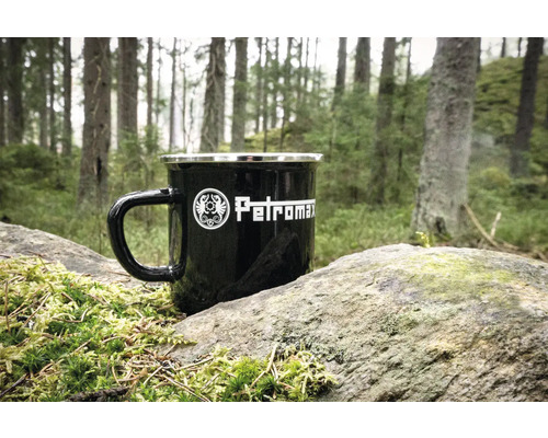 Tasse noire en émail Petromax sur une pierre dans la forêt