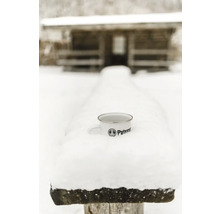 Emailletasse mit Petronam Logo im Schnee vor Holzhütte