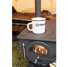 Eine Petromax Emaille Tasse steht auf einem Petromax Holzofen, in dem ein Feuer brennt.