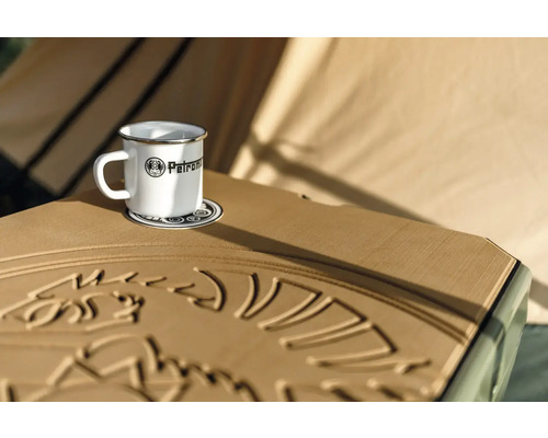 Tasse en émail avec le logo Petromax sur un dessous de verre sur une table