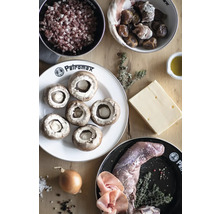Zutaten für Pilzpfanne mit Speckwürfeln, Datteln, Käse, Wildfleisch, Zwiebeln und Kräutern auf Holztisch