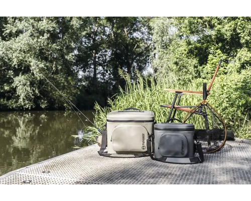 Szene mit zwei Petromax Kühltaschen, einem Angelstuhl, einem Kescher und einer Angel am Wasser