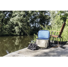 Szene mit Kühlbox, Angeltasche, Angelrute und Angelstuhl am Flussufer