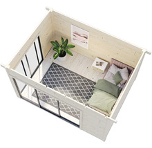 Innenansicht eines Gartenhauses mit Bett, Teppich, Zimmerpflanze und Fenster