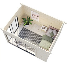 Intérieur d''une maison de jardin en bois avec lit, tapis et plante d''intérieur