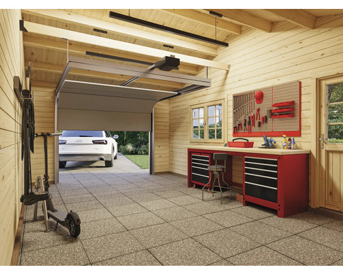 Garage avec établi, panneau à outils, porte de garage et voiture