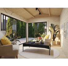 Salon lumineux avec lambris, fauteuils, table et plantes