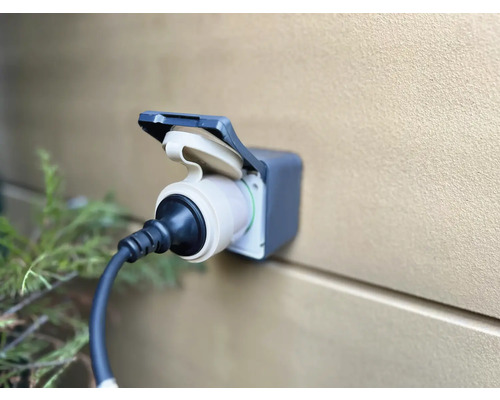 Elektroauto Ladestation mit angeschlossenem Stecker an einer Wand