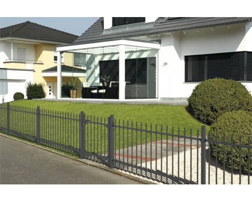 Haus mit Glasanbau und Metallzaun