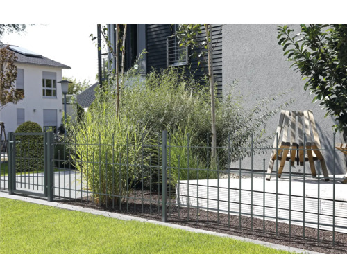 Gartenszene mit Metallzaun zur Grundstücksbegrenzung.