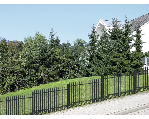 Gartenzaun aus Metall vor Garten und Wohnhaus