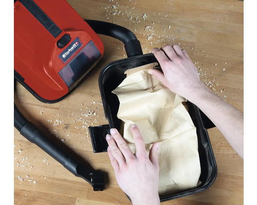 Einhell Logo. Detailansicht eines Staubsaugers mit eingesetztem Staubbeutel.
