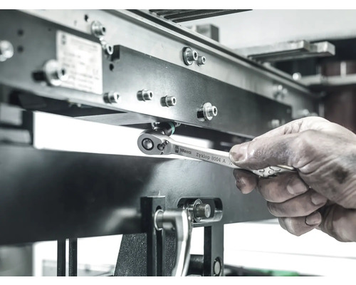 Ein Arbeiter benutzt einen Wera Zyklop 8004 A Ringschlüssel, um eine Schraube an einer Metallstruktur festzuziehen.