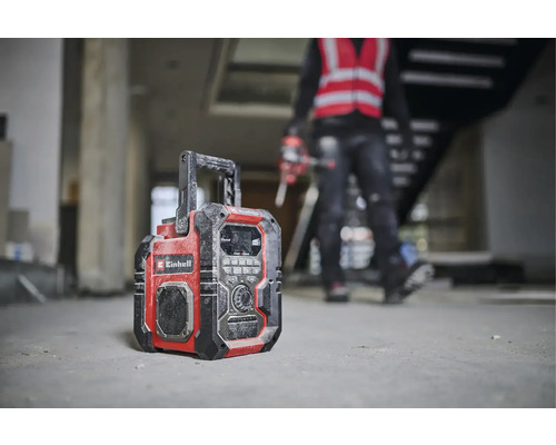 Une radio de chantier de la marque Einhell se trouve sur le sol d''un bâtiment en construction.