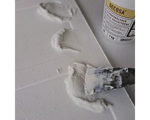 Application de colle polystyrène Decosa sur une plaque de polystyrène avec un couteau à mastic
