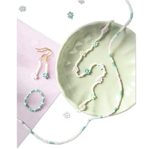 Ensemble de bijoux en perles avec collier, bague et boucles d''oreilles dans un bol vert clair