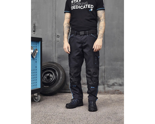 Une personne porte un pantalon de travail avec une ceinture et des chaussures de sécurité.