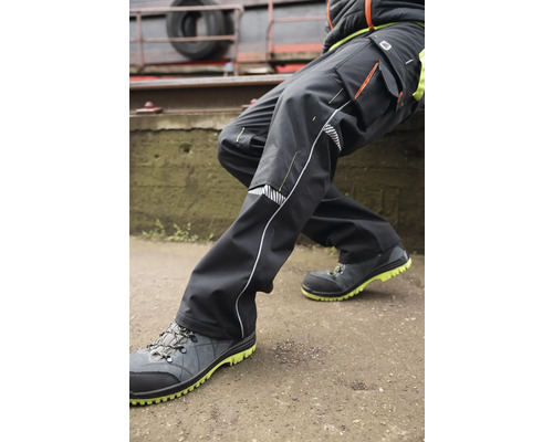 Person trägt Arbeitshose und Sicherheitsschuhe