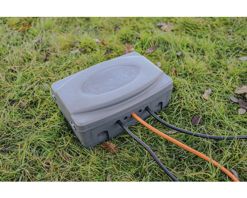 Verteilerkasten mit Stromkabeln im Gras