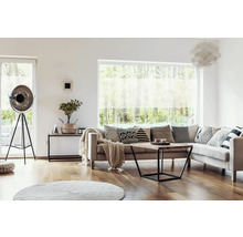 Salon avec canapé, coussins, table basse, lampadaire et fenêtre