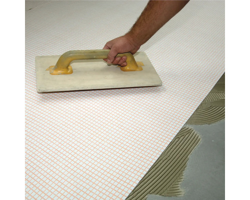 Verarbeitung von Entkopplungsmatte mit Glättkelle auf dem Boden