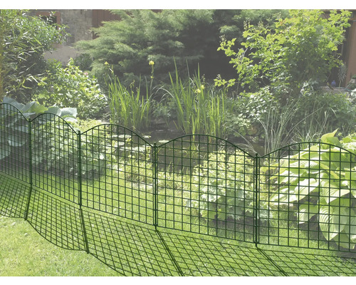 Dekorativer Gartenzaun aus Metall zur Beetbegrenzung im Garten.