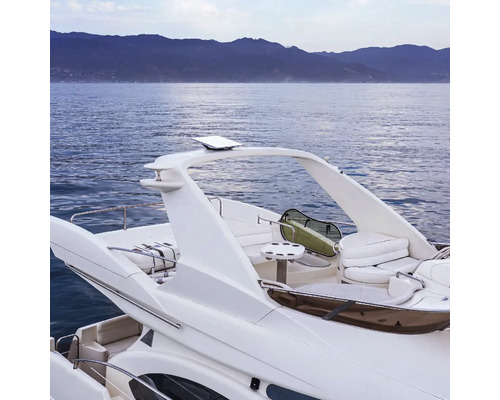 Vue arrière d''un bateau à moteur blanc sur l''eau avec des montagnes en arrière-plan