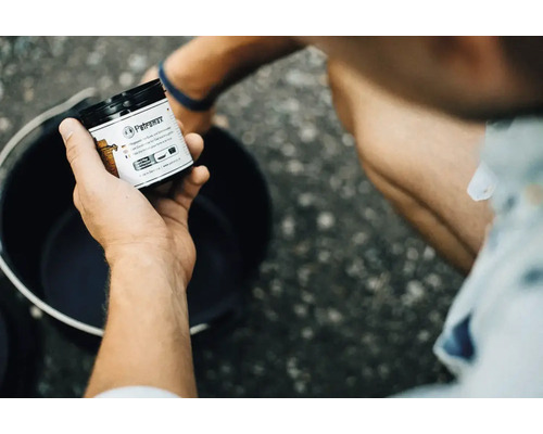 Petromax Pflegeprodukt für Guss und Schmiedeeisen in einer Hand gehalten