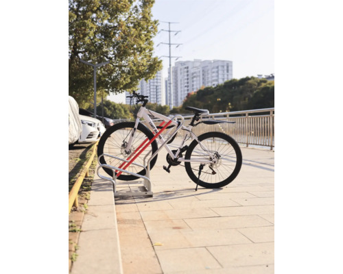 Vélo garé dans un range-vélos devant un paysage urbain