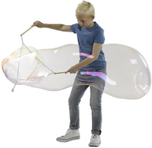 Junge macht eine riesige Seifenblase mit Seifenblasenstab