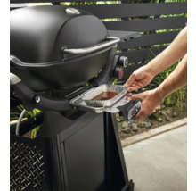 Barbecue Weber avec une personne insérant un bac de récupération