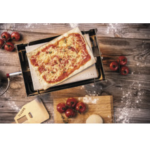 Four à pizza avec pizza, pelle à pizza, tomates et pâte sur une table en bois