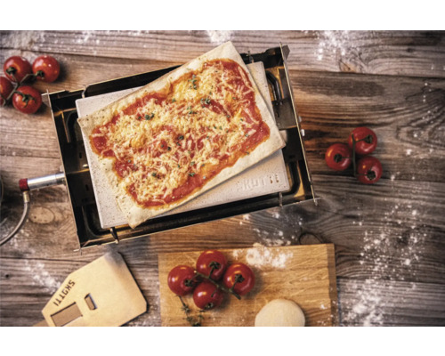 Four à pizza avec pizza, pelle à pizza, tomates et pâte sur une table en bois