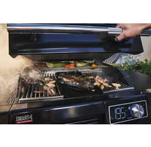 Un barbecue avec du poisson, des légumes et des copeaux de bois en cours de préparation.