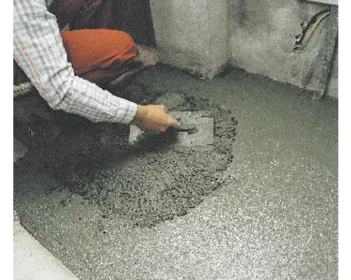 Artisan lissant une chape avec une truelle