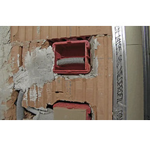 Installation d''une boîte d''appareil dans un mur en briques avec un tube vide.