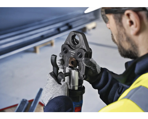 Ein Arbeiter bedient eine Bosch Rohpresszange.