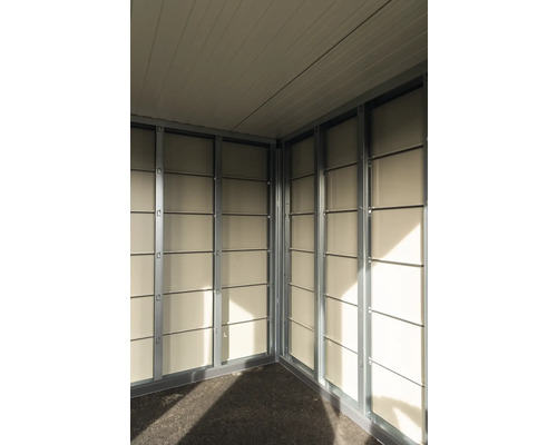Vue intérieure d''une cabane de jardin avec cadre en métal et panneaux muraux.