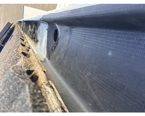 Vue détaillée d''une gouttière avec étanchéité bitumineuse et tuyau de descente