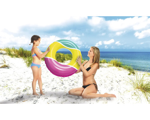 Mère et fille tenant une bouée de natation sur la plage