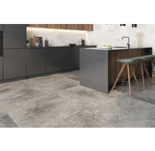 Cuisine moderne avec îlot de cuisine, tabourets de bar et carrelage au sol imitation pierre.